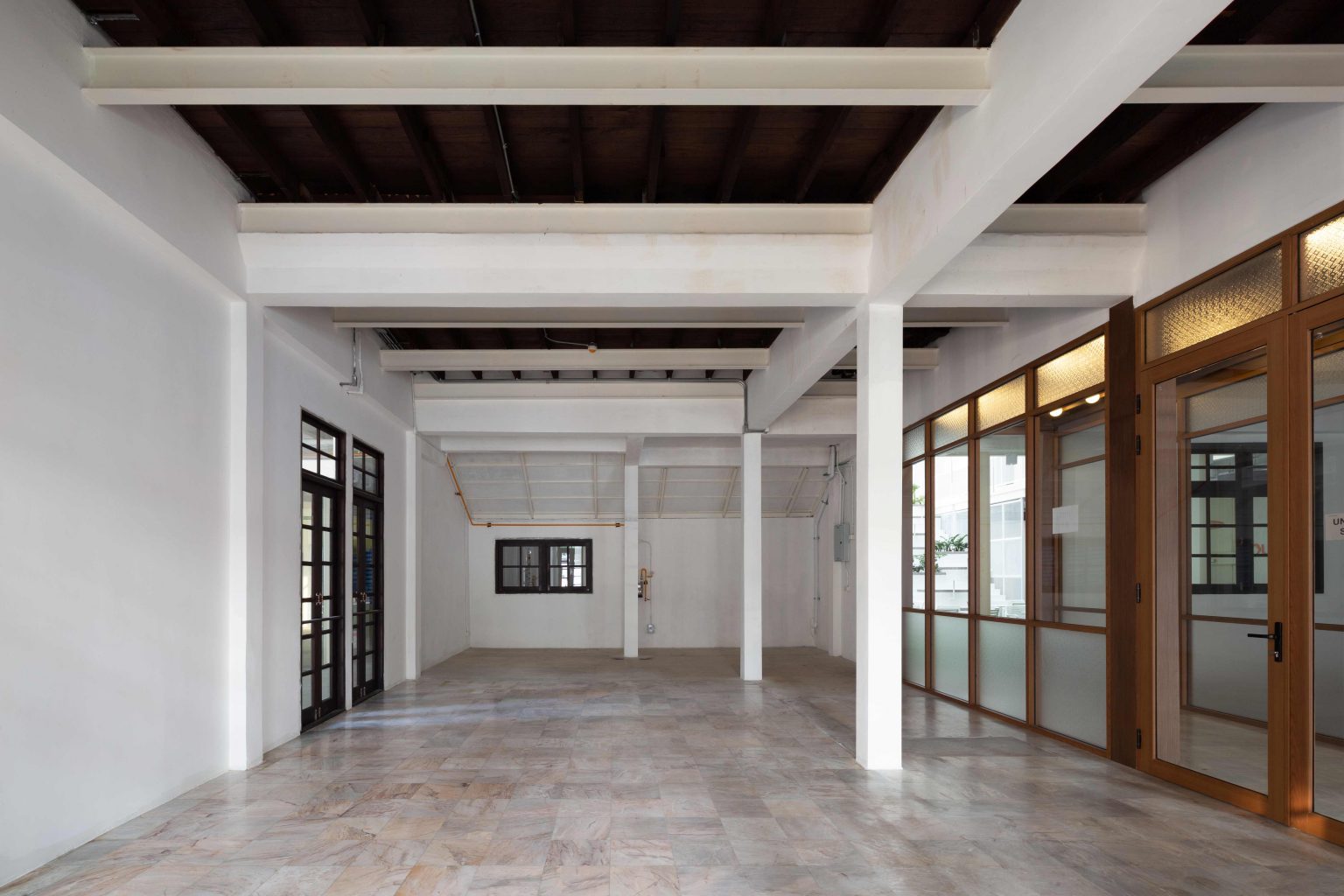 White Cloud Community Space – Community ฟีลบ้านเพื่อน ในพื้นที่บ้านเก่าอนุรักษ์และโครงสร้างใหม่จากเหล็ก SYS White Cloud Community Space เป็นการออกแบบพื้นที่ให้เช่าและ Community Space บนพื้นที่ย่านอารีย์ที่แต่เดิมมีบ้านหลังเก่าตั้งอยู่ โดยโจทย์ตั้งต้นคือการคงบ้านหลังเดิมที่มีความทรงจำและความสำคัญต่อเจ้าของที่ดินเอาไว้ สถาปนิกจึงทำการออกแบบพื้นที่ใช้งานใหม่โอบล้อมบ้านหลังเก่า เปลี่ยนบ้านเป็นไฮไลท์ และสร้างพื้นที่ใช้งานในร่มโอบล้อมโดยรอบ เพื่อให้ผู้คนเข้ามาใช้งานได้อย่างสะดวกสบายตลอดทั้งวัน ในพื้นที่อาคารประมาณ 1,200 ตารางเมตร (ไม่รวมพื้นที่จอดรถ) โครงการนี้ออกแบบโดย คุณอภิชัย จารุรัตนเกื้อ หรือคุณปริ้นท์ Architect Designer จาก Design to the Universe Co., Ltd. (บริษัท ดีไซน์ ทู เดอะ ยูนิเวิร์ส จำกัด) ผู้มีประสบการณ์ในการออกแบบงาน Commercial, Hospitality & Education Building ในหลากหลายโครงการ เช่น Holiday Pastry หน้าร้านชงดีที่ One Bangkok และ Central World หรือโรงพยาบาลหลายแห่ง เป็นผู้นำในการออกแบบ แบ่งสัดส่วนพื้นที่อย่างเป็นระบบ และสร้างเอกลักษณ์ให้กับแบรนด์ได้อย่างโดดเด่น ในโครงการ White Cloud Community Space ด้วยความต้องการให้ Space โปร่งโล่ง มีกรอบเวลาที่ชัดเจน และง่ายต่อการรื้อถอนหลังหมดสัญญาเช่า ทางสถาปนิกจึงเลือกใช้เหล็กโครงสร้าง H-BEAM จาก SYS เป็นโครงสร้างหลักของโครงการ เพราะมีคุณสมบัติที่ตอบโจทย์ทั้งงานดีไซน์ ความแข็งแรง และจัดการก่อสร้างได้สะดวก ส่งผลให้โครงการนี้เสร็จสิ้นได้รวดเร็ว มีดีไซน์ที่โปร่งโล่ง ไม่มีเสาโผล่กลางพื้นที่และตอบโจทย์เรื่องการรักษ์โลกได้จริง เป็น Community Space ยุคใหม่ ที่คุ้มค่าต่อเจ้าของโครงการในระยะยาว อีกทั้งยังสร้างความประทับใจ ความทรงจำ และประสบการณ์การใช้งานที่อบอุ่นและพิเศษให้กับผู้คนได้ทุกครั้งที่เข้ามาใช้งาน จากบ้านเก่าย่านอารีย์สู่ Community แห่งใหม่ในคอนเซ็ปต์ไข่แดง โครงการ White Cloud Community Space เริ่มต้นมาจากเจ้าของโครงการที่ต้องการเปลี่ยนบ้านเช่าหลังเก่าที่มีเอกลักษณ์เฉพาะตัวในย่านอารีย์ กรุงเทพมหานคร ให้กลายเป็น Commercial Building ที่ผู้คนสามารถเข้ามาใช้งานได้อย่างอิสระ ในขณะเดียวกันก็เปิดพื้นที่เช่าให้กับร้านค้าต่าง ๆ เข้ามาประกอบกิจกรรม ออกแบบโดยคุณอภิชัย จารุรัตนเกื้อ หรือคุณปริ้นท์ Architect Designer จาก Design to the Universe Co., Ltd. (บริษัท ดีไซน์ ทู เดอะ ยูนิเวิร์ส จำกัด) เดิมพื้นที่มีบ้านเก่า 2 ชั้นตั้งอยู่ และด้วยการเป็นพื้นที่เช่า เมื่อจบสัญญาเช่าเจ้าของโครงการจำเป็นต้องคืนพื้นที่ในสภาพเดิม ดังนั้นโครงการจึงเน้นไปที่การต่อเติมและสร้างโครงสร้างใหม่เข้ามาเสริม เพื่อรักษาโครงสร้างของบ้านเดิมเอาไว้ให้มากที่สุด และถือโอกาสชูบ้านหลังนี้ให้เป็นจุดเด่นของโครงการด้วย ทำให้บรรยากาศเสมือนการมานั่งเล่นที่บ้านเพื่อน เมื่อต้องการรักษาโครงสร้างเดิมของตัวบ้านเอาไว้ สถาปนิกจึงใช้การออกแบบและวางโครงสร้างส่วนใหม่เข้าไปรอบบ้านแทน เปรียบเสมือน “ไข่แดง (ตัวบ้านเดิม)” ที่ถูกล้อมรอบด้วย “ไข่ขาว (โครงสร้างใหม่)” โดยมีการวางพื้นที่จอดรถไว้ด้านหน้า ช่วยสร้างระยะการรับรู้จากถนน ให้ผู้ใช้งานสามารถมองเห็นความสวยงามของสถาปัตยกรรมและสัมผัสได้ถึงบรรยากาศสบาย ๆ ของโครงการได้ตั้งแต่ทางเข้า ส่วนตัวบ้านเดิมจะเป็นกระบวนการแบบ “กึ่งอนุรักษ์” คือพยายามรักษาวัสดุ โครงสร้างเดิมเอาไว้ เพื่อให้ความทรงจำของบ้านเด่นชัดและสื่อสารความรู้สึกแก่ผู้เข้ามาใช้งานได้อย่างชัดเจนที่สุด นอกจากนี้ยังใช้ “สวน” เพื่อแบ่งโซนการใช้งาน คือ สวนหน้าบ้าน เพิ่มความเขียวให้โครงการดูร่มรื่น และสวนหลังบ้านที่เป็นไฮไลท์ของโครงการ ที่มีร้านค้าหลากหลาย รวมถึงที่นั่ง บริเวณนี้จึงเกิดกิจกรรมและการเคลื่อนไหวค่อนข้างมาก เสริมให้โครงการมีชีวิตชีวามากขึ้น โครงการสีขาว เบาสบาย กับโจทย์ตั้งต้นที่โครงสร้างเหล็กกลายมาเป็นคำตอบ จากโจทย์หลักที่เป็นพื้นที่เช่า “โครงสร้างเหล็ก” จึงกลายเป็นคำตอบที่ชัดเจนสำหรับการออกแบบ เพราะโครงสร้างเหล็กสามารถต่อเติมได้สะดวกและรวดเร็วในพื้นที่ทุกขนาด เช่นเดียวกับโครงการนี้ที่ถนนหน้าโครงการค่อนข้างแคบ การเลือกความยาวเหล็กสำเร็จมาจากโรงงานทำให้การขนส่งเข้ามายังหน้างานเป็นไปอย่างราบรื่น อีกทั้งเหล็กยังสามารถติดตั้งได้รวดเร็ว ไม่กระทบโครงสร้างบ้านหลัก ตลอดจนไม่ก่อมลภาวะทางเสียงหรือฝุ่นให้กับบริบทข้างเคียงที่เป็นย่านที่พักอาศัย โดย White Cloud Community Space ใช้เวลาในการจัดการโครงสร้างเหล็กประมาณ 6 เดือนเท่านั้น (หากรวมระยะเวลาออกแบบจะใช้เวลา 9 เดือน) คุณปรินท์เล่าถึงความสำคัญของ “เวลา” ในโครงการประเภท Commercial Building ว่าโครงการประเภทนี้มักจะมีระยะเวลาในการเกิดชัดเจน ดังนั้นจึงเป็นเรื่องสำคัญมากในการเลือกใช้วัสดุให้เหมาะกับแบบที่คิดไว้และระยะเวลาที่มี ซึ่งเหล็ก H-BEAM จาก SYS ก็ตอบโจทย์ทั้งเรื่องระยะเวลาและรองรับรูปแบบของดีไซน์ที่ต้องการได้เป็นอย่างดี ไม่ว่าจะเป็นความโปร่ง เบา บางของโครงสร้าง เพื่อให้อาคารดูทันสมัย เท่เรียบง่าย แต่ไม่บดบังตัวตนของบ้านเดิม Span (ระยะห่างระหว่างเสา) ที่ยืดได้ยาวขึ้น เป็นอีกหนึ่งข้อดีของการเลือกใช้เหล็กเช่นกัน เมื่อเทียบกับโครงสร้างคอนกรีตที่ต้องมีการหล่อโครงสร้างเสาคาน อาจต้องมีคานทุก 4 เมตร ทำให้หนัาตัดคานอยู่ที่ประมาณ 40 – 50 เซนติเมตร (รวมความหนาคอนกรีตที่เททับด้านบนพื้น) แต่เมื่อเป็นโครงสร้างเหล็ก สามารถยืด Span ได้กว้างกว่าเดิม อีกทั้งในโครงการยังเลือกใช้โครงสร้าง Steel Truss ทำให้ยืดได้กว้างขึ้น ใช้จำนวนเสาในการรับน้ำหนักน้อยลง ส่งผลให้พื้นที่มีความโปร่งโล่งได้อย่างที่ต้องการ Highlight โถงสูงกลางบ้าน สร้างพื้นที่ให้กิจกรรมเชื่อมโยงถึงกัน สถาปนิกมองเผื่อไปยังอนาคตว่า ณ Community Space แห่งนี้อาจมีการขยายตัวของกิจกรรม เช่น การจัดคอนเสิร์ต จัดงานอีเวนต์ หรือทำการแสดงต่าง ๆ ซึ่งจะมีการรวมตัวของผู้คนจำนวนมาก ดังนั้นจึงเป็นแนวคิดที่ดีหากในโครงการมีพื้นที่โถงกลางเพื่อรองรับกิจกรรมนั้น โดยเมื่อเดินเข้ามาด้านในอาคาร จะเจอกับโถง Double Space ที่ฝ้าสูงประมาณ 7 – 8 เมตร มีพื้นที่ลานขนาดใหญ่ และมีการออกแบบเป็นอัฒจรรย์หรือ Amphitheater สีขาวขนาดใหญ่ที่สามารถใช้เป็นทั้งบันไดเชื่อมต่อไปยังชั้น 2 ของอาคารและใช้เป็นที่นั่งได้ ส่วนฝ้าเพดานออกแบบให้เป็นตารางรังผึ้ง มีการสลับกับช่องเปิดเพื่อนำแสงธรรมชาติลงมาสู่พื้นที่ผ่านหลังคาลอนคู่ใส 2 โทนสี คือ ลอนใสและลอนที่เคลือบสีเหลืองอบอุ่น ช่วยลดการเปิดไฟในตอนกลางวันและทำให้โถงสว่างเพียงพอต่อการใช้งาน อีกทั้งยังได้แสงที่นุ่มนวลและมีมิติมากขึ้น นอกจากนี้ยังมีการเติมรายละเอียดตามจุดต่าง ๆ ของอาคารเพื่อให้ภาพลักษณ์ สีสันที่ดูขาวสว่าง โปร่งโล่งนั้นเชื่อมโยงโดยทั่วกัน ผ่านดีไซน์ของขาโต๊ะที่ใช้เหล็ก H-BEAM นำมาตัดให้ได้ระยะใช้งานที่เหมาะสม หรือการเพิ่มฉากระแนงสีขาวแบ่งพื้นที่ใช้งานให้เป็นสัดส่วนแต่ยังคงเชื่อมโยงถึงกันผ่านการมองเห็น หลังคาที่ถูกยกความสูง เพิ่มความโปร่งให้ Space เหล็ก H-BEAM จาก SYS ไม่ได้ถูกใช้เป็นโครงสร้างของอาคารหลังใหม่เพียงเท่านั้น แต่ยังถูกใช้เพิ่มต่อเติมและเสริมให้บ้านเดิมมีความโปร่งโล่งแข็งแรงมากขึ้น ดีเทลหนึ่งที่น่าสนใจของโครงการ คือการใช้เหล็ก H-BEAM เข้ามายกความสูงของโครงสร้างหลังคาของบ้านเดิมขึ้น จากเดิมที่เพดานชั้นสองของบ้านค่อนข้างต่ำ เมื่อถูกรื้อฝ้าออกเพื่อโชว์ให้เห็น Slope ของโครงหลังคา ทำให้พื้นที่ภายในดูโปร่งมากขึ้น ส่วนของชั้นหนึ่งเองก็มีการยกเพดานขึ้นเช่นกัน โดยใช้โครงสร้างเหล็กต่อเข้ากับโครงสร้างคอนกรีตเดิมเพื่อพยุงโครงสร้างบ้านทั้งหมดให้มั่นคง อีกทั้งยังมีการรื้อฝ้าเพดานออกเพื่อให้พื้นที่ได้ความสูงโปร่งมากขึ้น โครงสร้างเหล็ก H-BEAM สีขาวที่ต่อเติมเข้ามามีความทันสมัยที่ตัดกับบรรยากาศบ้านโมเดิร์นที่ดูย้อนยุค ทำให้เกิด Contrast ของพื้นที่ที่น่าสนใจ เสมือนเดินเข้าสู่อาคารอนุรักษ์แบบร่วมสมัย เหล็ก = วัสดุที่ตอบโจทย์คุ้มค่าตั้งแต่วันแรกที่เลือกใช้ จนถึงวันสุดท้ายที่รื้อถอนอาคาร จากการที่ได้พูดคุยถึงขั้นตอนการคิด การออกแบบ และการก่อสร้างของโครงการ White Cloud Community Space กับคุณปรินท์ ทำให้ทราบว่า “สถาปนิก” หรือ “ผู้ออกแบบ” มีส่วนสำคัญที่ช่วยให้ความรู้ในเรื่องวัสดุที่เหมาะสมกับเจ้าของโครงการเป็นอย่างมาก เช่นเดียวกับในโครงการนี้ที่ทางคุณปรินท์ได้มีการเล่าเกี่ยวกับการเลือกใช้เหล็ก H-BEAM ที่นอกจากจะช่วยให้ภาพที่ออกแบบเป็นจริงตามที่ต้องการแล้ว ยังมีข้อดีอีกหลายอย่างในเชิงการใช้งาน เช่น ความรวดเร็ว ความเพรียวบางของโครงสร้าง เป็นโครงสร้างที่ไม่มีฝุ่น และที่สำคัญ คือในวันที่หมดสัญญาเช่า สามารถรื้อถอนได้ทันที สามารถขายหรือรีไซเคิลใช้งานต่อได้ ซึ่งทั้งหมดนี้ตอบโจทย์ความคุ้มค่าให้กับลูกค้าได้ในหลากหลายมุม ทั้งความใส่ใจของแบรนด์ที่มีต่ออาคารข้างเคียง และการคิดเผื่อด้านสิ่งแวดล้อมของโครงการซึ่งเป็นสิ่งที่ทั่วโลกต่างให้ความสำคัญอยู่ ณ เวลานี้ งานออกแบบที่สะท้อนให้เห็นความยืดหยุ่นในการใช้เหล็ก H-BEAM ในงานสถาปัตยกรรม (กึ่งอนุรักษ์ จากโครงการที่มีโครงสร้างบ้านเดิมอยู่แล้ว) และการก่อสร้าง ที่ช่วยสร้างเอกลักษณ์ให้กับโครงการ และตอบโจทย์หรือเงื่อนไขของโครงการได้อย่างตรงจุด ทั้งในเชิงความแข็งแรง ความสวยงาม และความยั่งยืน สนใจสินค้าเหล็ก H-BEAM และบริการจาก SYS สามารถติดต่อสอบถามได้ทางช่องทาง WEBSITE-SYS STEEL: https://bit.ly/3qYADQ0 YOUTUBE: http://bit.ly/3asNqnp LINE: https://bit.ly/3gEI0tz TikTok: https://bit.ly/46AnaTP White Cloud Community Space – Community ฟีลบ้านเพื่อน ในพื้นที่บ้านเก่าอนุรักษ์และโครงสร้างใหม่จากเหล็ก SYS White Cloud Community Space เป็นการออกแบบพื้นที่ให้เช่าและ Community Space บนพื้นที่ย่านอารีย์ที่แต่เดิมมีบ้านหลังเก่าตั้งอยู่ โดยโจทย์ตั้งต้นคือการคงบ้านหลังเดิมที่มีความทรงจำและความสำคัญต่อเจ้าของที่ดินเอาไว้ สถาปนิกจึงทำการออกแบบพื้นที่ใช้งานใหม่โอบล้อมบ้านหลังเก่า เปลี่ยนบ้านเป็นไฮไลท์ และสร้างพื้นที่ใช้งานในร่มโอบล้อมโดยรอบ เพื่อให้ผู้คนเข้ามาใช้งานได้อย่างสะดวกสบายตลอดทั้งวัน ในพื้นที่อาคารประมาณ 1,200 ตารางเมตร (ไม่รวมพื้นที่จอดรถ) โครงการนี้ออกแบบโดย คุณอภิชัย จารุรัตนเกื้อ หรือคุณปริ้นท์ Architect Designer จาก Design to the Universe Co., Ltd. (บริษัท ดีไซน์ ทู เดอะ ยูนิเวิร์ส จำกัด) ผู้มีประสบการณ์ในการออกแบบงาน Commercial, Hospitality & Education Building ในหลากหลายโครงการ เช่น Holiday Pastry หน้าร้านชงดีที่ One Bangkok และ Central World หรือโรงพยาบาลหลายแห่ง เป็นผู้นำในการออกแบบ แบ่งสัดส่วนพื้นที่อย่างเป็นระบบ และสร้างเอกลักษณ์ให้กับแบรนด์ได้อย่างโดดเด่น ในโครงการ White Cloud Community Space ด้วยความต้องการให้ Space โปร่งโล่ง มีกรอบเวลาที่ชัดเจน และง่ายต่อการรื้อถอนหลังหมดสัญญาเช่า ทางสถาปนิกจึงเลือกใช้เหล็กโครงสร้าง H-BEAM จาก SYS เป็นโครงสร้างหลักของโครงการ เพราะมีคุณสมบัติที่ตอบโจทย์ทั้งงานดีไซน์ ความแข็งแรง และจัดการก่อสร้างได้สะดวก ส่งผลให้โครงการนี้เสร็จสิ้นได้รวดเร็ว มีดีไซน์ที่โปร่งโล่ง ไม่มีเสาโผล่กลางพื้นที่และตอบโจทย์เรื่องการรักษ์โลกได้จริง เป็น Community Space ยุคใหม่ ที่คุ้มค่าต่อเจ้าของโครงการในระยะยาว อีกทั้งยังสร้างความประทับใจ ความทรงจำ และประสบการณ์การใช้งานที่อบอุ่นและพิเศษให้กับผู้คนได้ทุกครั้งที่เข้ามาใช้งาน จากบ้านเก่าย่านอารีย์สู่ Community แห่งใหม่ในคอนเซ็ปต์ไข่แดง โครงการ White Cloud Community Space เริ่มต้นมาจากเจ้าของโครงการที่ต้องการเปลี่ยนบ้านเช่าหลังเก่าที่มีเอกลักษณ์เฉพาะตัวในย่านอารีย์ กรุงเทพมหานคร ให้กลายเป็น Commercial Building ที่ผู้คนสามารถเข้ามาใช้งานได้อย่างอิสระ ในขณะเดียวกันก็เปิดพื้นที่เช่าให้กับร้านค้าต่าง ๆ เข้ามาประกอบกิจกรรม ออกแบบโดยคุณอภิชัย จารุรัตนเกื้อ หรือคุณปริ้นท์ Architect Designer จาก Design to the Universe Co., Ltd. (บริษัท ดีไซน์ ทู เดอะ ยูนิเวิร์ส จำกัด) เดิมพื้นที่มีบ้านเก่า 2 ชั้นตั้งอยู่ และด้วยการเป็นพื้นที่เช่า เมื่อจบสัญญาเช่าเจ้าของโครงการจำเป็นต้องคืนพื้นที่ในสภาพเดิม ดังนั้นโครงการจึงเน้นไปที่การต่อเติมและสร้างโครงสร้างใหม่เข้ามาเสริม เพื่อรักษาโครงสร้างของบ้านเดิมเอาไว้ให้มากที่สุด และถือโอกาสชูบ้านหลังนี้ให้เป็นจุดเด่นของโครงการด้วย ทำให้บรรยากาศเสมือนการมานั่งเล่นที่บ้านเพื่อน เมื่อต้องการรักษาโครงสร้างเดิมของตัวบ้านเอาไว้ สถาปนิกจึงใช้การออกแบบและวางโครงสร้างส่วนใหม่เข้าไปรอบบ้านแทน เปรียบเสมือน “ไข่แดง (ตัวบ้านเดิม)” ที่ถูกล้อมรอบด้วย “ไข่ขาว (โครงสร้างใหม่)” โดยมีการวางพื้นที่จอดรถไว้ด้านหน้า ช่วยสร้างระยะการรับรู้จากถนน ให้ผู้ใช้งานสามารถมองเห็นความสวยงามของสถาปัตยกรรมและสัมผัสได้ถึงบรรยากาศสบาย ๆ ของโครงการได้ตั้งแต่ทางเข้า ส่วนตัวบ้านเดิมจะเป็นกระบวนการแบบ “กึ่งอนุรักษ์” คือพยายามรักษาวัสดุ โครงสร้างเดิมเอาไว้ เพื่อให้ความทรงจำของบ้านเด่นชัดและสื่อสารความรู้สึกแก่ผู้เข้ามาใช้งานได้อย่างชัดเจนที่สุด นอกจากนี้ยังใช้ “สวน” เพื่อแบ่งโซนการใช้งาน คือ สวนหน้าบ้าน เพิ่มความเขียวให้โครงการดูร่มรื่น และสวนหลังบ้านที่เป็นไฮไลท์ของโครงการ ที่มีร้านค้าหลากหลาย รวมถึงที่นั่ง บริเวณนี้จึงเกิดกิจกรรมและการเคลื่อนไหวค่อนข้างมาก เสริมให้โครงการมีชีวิตชีวามากขึ้น โครงการสีขาว เบาสบาย กับโจทย์ตั้งต้นที่โครงสร้างเหล็กกลายมาเป็นคำตอบ จากโจทย์หลักที่เป็นพื้นที่เช่า “โครงสร้างเหล็ก” จึงกลายเป็นคำตอบที่ชัดเจนสำหรับการออกแบบ เพราะโครงสร้างเหล็กสามารถต่อเติมได้สะดวกและรวดเร็วในพื้นที่ทุกขนาด เช่นเดียวกับโครงการนี้ที่ถนนหน้าโครงการค่อนข้างแคบ การเลือกความยาวเหล็กสำเร็จมาจากโรงงานทำให้การขนส่งเข้ามายังหน้างานเป็นไปอย่างราบรื่น อีกทั้งเหล็กยังสามารถติดตั้งได้รวดเร็ว ไม่กระทบโครงสร้างบ้านหลัก ตลอดจนไม่ก่อมลภาวะทางเสียงหรือฝุ่นให้กับบริบทข้างเคียงที่เป็นย่านที่พักอาศัย โดย White Cloud Community Space ใช้เวลาในการจัดการโครงสร้างเหล็กประมาณ 6 เดือนเท่านั้น (หากรวมระยะเวลาออกแบบจะใช้เวลา 9 เดือน) คุณปรินท์เล่าถึงความสำคัญของ “เวลา” ในโครงการประเภท Commercial Building ว่าโครงการประเภทนี้มักจะมีระยะเวลาในการเกิดชัดเจน ดังนั้นจึงเป็นเรื่องสำคัญมากในการเลือกใช้วัสดุให้เหมาะกับแบบที่คิดไว้และระยะเวลาที่มี ซึ่งเหล็ก H-BEAM จาก SYS ก็ตอบโจทย์ทั้งเรื่องระยะเวลาและรองรับรูปแบบของดีไซน์ที่ต้องการได้เป็นอย่างดี ไม่ว่าจะเป็นความโปร่ง เบา บางของโครงสร้าง เพื่อให้อาคารดูทันสมัย เท่เรียบง่าย แต่ไม่บดบังตัวตนของบ้านเดิม Span (ระยะห่างระหว่างเสา) ที่ยืดได้ยาวขึ้น เป็นอีกหนึ่งข้อดีของการเลือกใช้เหล็กเช่นกัน เมื่อเทียบกับโครงสร้างคอนกรีตที่ต้องมีการหล่อโครงสร้างเสาคาน อาจต้องมีคานทุก 4 เมตร ทำให้หนัาตัดคานอยู่ที่ประมาณ 40 – 50 เซนติเมตร (รวมความหนาคอนกรีตที่เททับด้านบนพื้น) แต่เมื่อเป็นโครงสร้างเหล็ก สามารถยืด Span ได้กว้างกว่าเดิม อีกทั้งในโครงการยังเลือกใช้โครงสร้าง Steel Truss ทำให้ยืดได้กว้างขึ้น ใช้จำนวนเสาในการรับน้ำหนักน้อยลง ส่งผลให้พื้นที่มีความโปร่งโล่งได้อย่างที่ต้องการ Highlight โถงสูงกลางบ้าน สร้างพื้นที่ให้กิจกรรมเชื่อมโยงถึงกัน สถาปนิกมองเผื่อไปยังอนาคตว่า ณ Community Space แห่งนี้อาจมีการขยายตัวของกิจกรรม เช่น การจัดคอนเสิร์ต จัดงานอีเวนต์ หรือทำการแสดงต่าง ๆ ซึ่งจะมีการรวมตัวของผู้คนจำนวนมาก ดังนั้นจึงเป็นแนวคิดที่ดีหากในโครงการมีพื้นที่โถงกลางเพื่อรองรับกิจกรรมนั้น โดยเมื่อเดินเข้ามาด้านในอาคาร จะเจอกับโถง Double Space ที่ฝ้าสูงประมาณ 7 – 8 เมตร มีพื้นที่ลานขนาดใหญ่ และมีการออกแบบเป็นอัฒจรรย์หรือ Amphitheater สีขาวขนาดใหญ่ที่สามารถใช้เป็นทั้งบันไดเชื่อมต่อไปยังชั้น 2 ของอาคารและใช้เป็นที่นั่งได้ ส่วนฝ้าเพดานออกแบบให้เป็นตารางรังผึ้ง มีการสลับกับช่องเปิดเพื่อนำแสงธรรมชาติลงมาสู่พื้นที่ผ่านหลังคาลอนคู่ใส 2 โทนสี คือ ลอนใสและลอนที่เคลือบสีเหลืองอบอุ่น ช่วยลดการเปิดไฟในตอนกลางวันและทำให้โถงสว่างเพียงพอต่อการใช้งาน อีกทั้งยังได้แสงที่นุ่มนวลและมีมิติมากขึ้น นอกจากนี้ยังมีการเติมรายละเอียดตามจุดต่าง ๆ ของอาคารเพื่อให้ภาพลักษณ์ สีสันที่ดูขาวสว่าง โปร่งโล่งนั้นเชื่อมโยงโดยทั่วกัน ผ่านดีไซน์ของขาโต๊ะที่ใช้เหล็ก H-BEAM นำมาตัดให้ได้ระยะใช้งานที่เหมาะสม หรือการเพิ่มฉากระแนงสีขาวแบ่งพื้นที่ใช้งานให้เป็นสัดส่วนแต่ยังคงเชื่อมโยงถึงกันผ่านการมองเห็น หลังคาที่ถูกยกความสูง เพิ่มความโปร่งให้ Space เหล็ก H-BEAM จาก SYS ไม่ได้ถูกใช้เป็นโครงสร้างของอาคารหลังใหม่เพียงเท่านั้น แต่ยังถูกใช้เพิ่มต่อเติมและเสริมให้บ้านเดิมมีความโปร่งโล่งแข็งแรงมากขึ้น ดีเทลหนึ่งที่น่าสนใจของโครงการ คือการใช้เหล็ก H-BEAM เข้ามายกความสูงของโครงสร้างหลังคาของบ้านเดิมขึ้น จากเดิมที่เพดานชั้นสองของบ้านค่อนข้างต่ำ เมื่อถูกรื้อฝ้าออกเพื่อโชว์ให้เห็น Slope ของโครงหลังคา ทำให้พื้นที่ภายในดูโปร่งมากขึ้น ส่วนของชั้นหนึ่งเองก็มีการยกเพดานขึ้นเช่นกัน โดยใช้โครงสร้างเหล็กต่อเข้ากับโครงสร้างคอนกรีตเดิมเพื่อพยุงโครงสร้างบ้านทั้งหมดให้มั่นคง อีกทั้งยังมีการรื้อฝ้าเพดานออกเพื่อให้พื้นที่ได้ความสูงโปร่งมากขึ้น โครงสร้างเหล็ก H-BEAM สีขาวที่ต่อเติมเข้ามามีความทันสมัยที่ตัดกับบรรยากาศบ้านโมเดิร์นที่ดูย้อนยุค ทำให้เกิด Contrast ของพื้นที่ที่น่าสนใจ เสมือนเดินเข้าสู่อาคารอนุรักษ์แบบร่วมสมัย เหล็ก = วัสดุที่ตอบโจทย์คุ้มค่าตั้งแต่วันแรกที่เลือกใช้ จนถึงวันสุดท้ายที่รื้อถอนอาคาร จากการที่ได้พูดคุยถึงขั้นตอนการคิด การออกแบบ และการก่อสร้างของโครงการ White Cloud Community Space กับคุณปรินท์ ทำให้ทราบว่า “สถาปนิก” หรือ “ผู้ออกแบบ” มีส่วนสำคัญที่ช่วยให้ความรู้ในเรื่องวัสดุที่เหมาะสมกับเจ้าของโครงการเป็นอย่างมาก เช่นเดียวกับในโครงการนี้ที่ทางคุณปรินท์ได้มีการเล่าเกี่ยวกับการเลือกใช้เหล็ก H-BEAM ที่นอกจากจะช่วยให้ภาพที่ออกแบบเป็นจริงตามที่ต้องการแล้ว ยังมีข้อดีอีกหลายอย่างในเชิงการใช้งาน เช่น ความรวดเร็ว ความเพรียวบางของโครงสร้าง เป็นโครงสร้างที่ไม่มีฝุ่น และที่สำคัญ คือในวันที่หมดสัญญาเช่า สามารถรื้อถอนได้ทันที สามารถขายหรือรีไซเคิลใช้งานต่อได้ ซึ่งทั้งหมดนี้ตอบโจทย์ความคุ้มค่าให้กับลูกค้าได้ในหลากหลายมุม ทั้งความใส่ใจของแบรนด์ที่มีต่ออาคารข้างเคียง และการคิดเผื่อด้านสิ่งแวดล้อมของโครงการซึ่งเป็นสิ่งที่ทั่วโลกต่างให้ความสำคัญอยู่ ณ เวลานี้ งานออกแบบที่สะท้อนให้เห็นความยืดหยุ่นในการใช้เหล็ก H-BEAM ในงานสถาปัตยกรรม (กึ่งอนุรักษ์ จากโครงการที่มีโครงสร้างบ้านเดิมอยู่แล้ว) และการก่อสร้าง ที่ช่วยสร้างเอกลักษณ์ให้กับโครงการ และตอบโจทย์หรือเงื่อนไขของโครงการได้อย่างตรงจุด ทั้งในเชิงความแข็งแรง ความสวยงาม และความยั่งยืน สนใจสินค้าเหล็ก H-BEAM และบริการจาก SYS สามารถติดต่อสอบถามได้ทางช่องทาง WEBSITE-SYS STEEL: https://bit.ly/3qYADQ0 YOUTUBE: http://bit.ly/3asNqnp LINE: https://bit.ly/3gEI0tz TikTok: https://bit.ly/46AnaTP