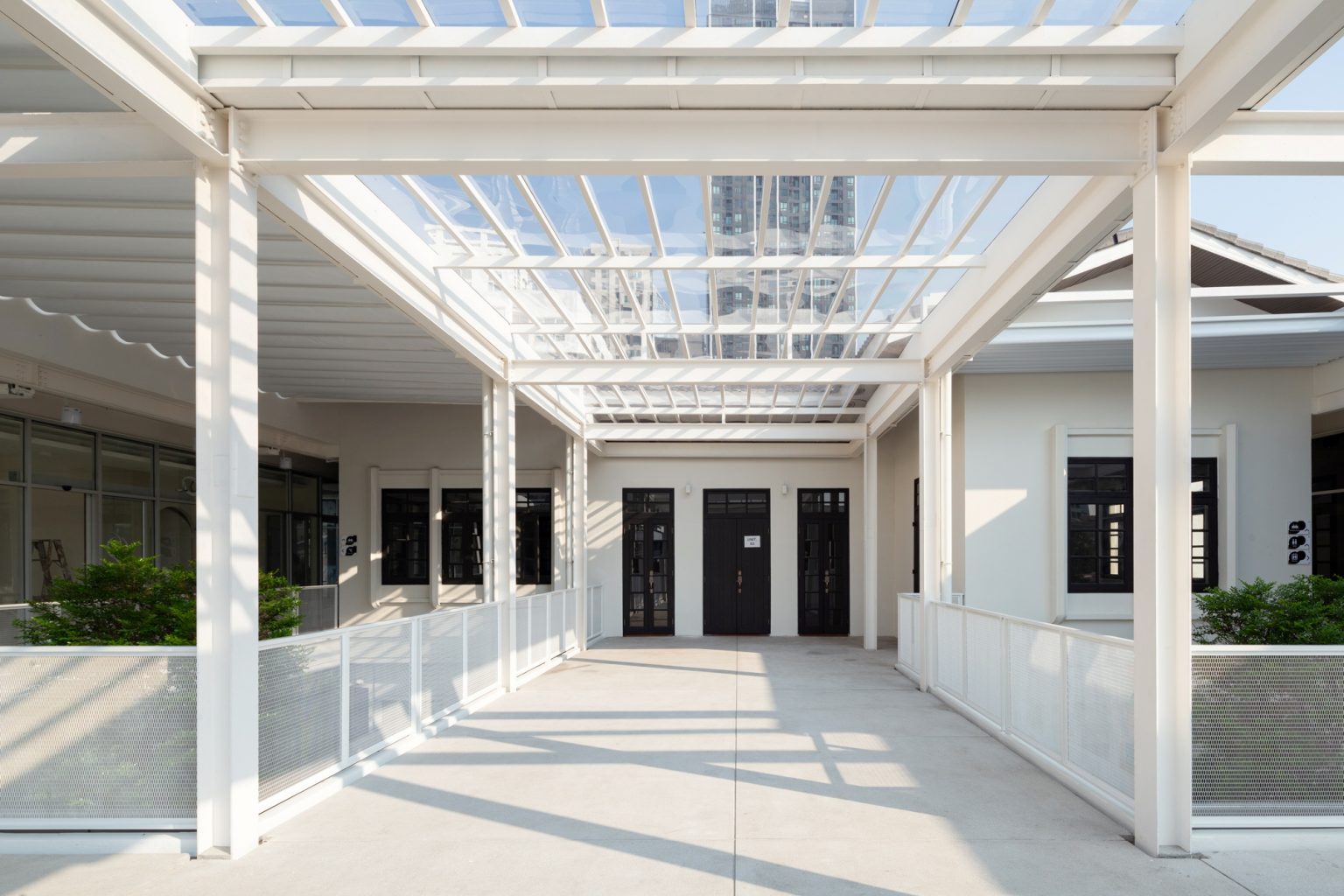 White Cloud Community Space – Community ฟีลบ้านเพื่อน ในพื้นที่บ้านเก่าอนุรักษ์และโครงสร้างใหม่จากเหล็ก SYS White Cloud Community Space เป็นการออกแบบพื้นที่ให้เช่าและ Community Space บนพื้นที่ย่านอารีย์ที่แต่เดิมมีบ้านหลังเก่าตั้งอยู่ โดยโจทย์ตั้งต้นคือการคงบ้านหลังเดิมที่มีความทรงจำและความสำคัญต่อเจ้าของที่ดินเอาไว้ สถาปนิกจึงทำการออกแบบพื้นที่ใช้งานใหม่โอบล้อมบ้านหลังเก่า เปลี่ยนบ้านเป็นไฮไลท์ และสร้างพื้นที่ใช้งานในร่มโอบล้อมโดยรอบ เพื่อให้ผู้คนเข้ามาใช้งานได้อย่างสะดวกสบายตลอดทั้งวัน ในพื้นที่อาคารประมาณ 1,200 ตารางเมตร (ไม่รวมพื้นที่จอดรถ) โครงการนี้ออกแบบโดย คุณอภิชัย จารุรัตนเกื้อ หรือคุณปริ้นท์ Architect Designer จาก Design to the Universe Co., Ltd. (บริษัท ดีไซน์ ทู เดอะ ยูนิเวิร์ส จำกัด) ผู้มีประสบการณ์ในการออกแบบงาน Commercial, Hospitality & Education Building ในหลากหลายโครงการ เช่น Holiday Pastry หน้าร้านชงดีที่ One Bangkok และ Central World หรือโรงพยาบาลหลายแห่ง เป็นผู้นำในการออกแบบ แบ่งสัดส่วนพื้นที่อย่างเป็นระบบ และสร้างเอกลักษณ์ให้กับแบรนด์ได้อย่างโดดเด่น ในโครงการ White Cloud Community Space ด้วยความต้องการให้ Space โปร่งโล่ง มีกรอบเวลาที่ชัดเจน และง่ายต่อการรื้อถอนหลังหมดสัญญาเช่า ทางสถาปนิกจึงเลือกใช้เหล็กโครงสร้าง H-BEAM จาก SYS เป็นโครงสร้างหลักของโครงการ เพราะมีคุณสมบัติที่ตอบโจทย์ทั้งงานดีไซน์ ความแข็งแรง และจัดการก่อสร้างได้สะดวก ส่งผลให้โครงการนี้เสร็จสิ้นได้รวดเร็ว มีดีไซน์ที่โปร่งโล่ง ไม่มีเสาโผล่กลางพื้นที่และตอบโจทย์เรื่องการรักษ์โลกได้จริง เป็น Community Space ยุคใหม่ ที่คุ้มค่าต่อเจ้าของโครงการในระยะยาว อีกทั้งยังสร้างความประทับใจ ความทรงจำ และประสบการณ์การใช้งานที่อบอุ่นและพิเศษให้กับผู้คนได้ทุกครั้งที่เข้ามาใช้งาน จากบ้านเก่าย่านอารีย์สู่ Community แห่งใหม่ในคอนเซ็ปต์ไข่แดง โครงการ White Cloud Community Space เริ่มต้นมาจากเจ้าของโครงการที่ต้องการเปลี่ยนบ้านเช่าหลังเก่าที่มีเอกลักษณ์เฉพาะตัวในย่านอารีย์ กรุงเทพมหานคร ให้กลายเป็น Commercial Building ที่ผู้คนสามารถเข้ามาใช้งานได้อย่างอิสระ ในขณะเดียวกันก็เปิดพื้นที่เช่าให้กับร้านค้าต่าง ๆ เข้ามาประกอบกิจกรรม ออกแบบโดยคุณอภิชัย จารุรัตนเกื้อ หรือคุณปริ้นท์ Architect Designer จาก Design to the Universe Co., Ltd. (บริษัท ดีไซน์ ทู เดอะ ยูนิเวิร์ส จำกัด) เดิมพื้นที่มีบ้านเก่า 2 ชั้นตั้งอยู่ และด้วยการเป็นพื้นที่เช่า เมื่อจบสัญญาเช่าเจ้าของโครงการจำเป็นต้องคืนพื้นที่ในสภาพเดิม ดังนั้นโครงการจึงเน้นไปที่การต่อเติมและสร้างโครงสร้างใหม่เข้ามาเสริม เพื่อรักษาโครงสร้างของบ้านเดิมเอาไว้ให้มากที่สุด และถือโอกาสชูบ้านหลังนี้ให้เป็นจุดเด่นของโครงการด้วย ทำให้บรรยากาศเสมือนการมานั่งเล่นที่บ้านเพื่อน เมื่อต้องการรักษาโครงสร้างเดิมของตัวบ้านเอาไว้ สถาปนิกจึงใช้การออกแบบและวางโครงสร้างส่วนใหม่เข้าไปรอบบ้านแทน เปรียบเสมือน “ไข่แดง (ตัวบ้านเดิม)” ที่ถูกล้อมรอบด้วย “ไข่ขาว (โครงสร้างใหม่)” โดยมีการวางพื้นที่จอดรถไว้ด้านหน้า ช่วยสร้างระยะการรับรู้จากถนน ให้ผู้ใช้งานสามารถมองเห็นความสวยงามของสถาปัตยกรรมและสัมผัสได้ถึงบรรยากาศสบาย ๆ ของโครงการได้ตั้งแต่ทางเข้า ส่วนตัวบ้านเดิมจะเป็นกระบวนการแบบ “กึ่งอนุรักษ์” คือพยายามรักษาวัสดุ โครงสร้างเดิมเอาไว้ เพื่อให้ความทรงจำของบ้านเด่นชัดและสื่อสารความรู้สึกแก่ผู้เข้ามาใช้งานได้อย่างชัดเจนที่สุด นอกจากนี้ยังใช้ “สวน” เพื่อแบ่งโซนการใช้งาน คือ สวนหน้าบ้าน เพิ่มความเขียวให้โครงการดูร่มรื่น และสวนหลังบ้านที่เป็นไฮไลท์ของโครงการ ที่มีร้านค้าหลากหลาย รวมถึงที่นั่ง บริเวณนี้จึงเกิดกิจกรรมและการเคลื่อนไหวค่อนข้างมาก เสริมให้โครงการมีชีวิตชีวามากขึ้น โครงการสีขาว เบาสบาย กับโจทย์ตั้งต้นที่โครงสร้างเหล็กกลายมาเป็นคำตอบ จากโจทย์หลักที่เป็นพื้นที่เช่า “โครงสร้างเหล็ก” จึงกลายเป็นคำตอบที่ชัดเจนสำหรับการออกแบบ เพราะโครงสร้างเหล็กสามารถต่อเติมได้สะดวกและรวดเร็วในพื้นที่ทุกขนาด เช่นเดียวกับโครงการนี้ที่ถนนหน้าโครงการค่อนข้างแคบ การเลือกความยาวเหล็กสำเร็จมาจากโรงงานทำให้การขนส่งเข้ามายังหน้างานเป็นไปอย่างราบรื่น อีกทั้งเหล็กยังสามารถติดตั้งได้รวดเร็ว ไม่กระทบโครงสร้างบ้านหลัก ตลอดจนไม่ก่อมลภาวะทางเสียงหรือฝุ่นให้กับบริบทข้างเคียงที่เป็นย่านที่พักอาศัย โดย White Cloud Community Space ใช้เวลาในการจัดการโครงสร้างเหล็กประมาณ 6 เดือนเท่านั้น (หากรวมระยะเวลาออกแบบจะใช้เวลา 9 เดือน) คุณปรินท์เล่าถึงความสำคัญของ “เวลา” ในโครงการประเภท Commercial Building ว่าโครงการประเภทนี้มักจะมีระยะเวลาในการเกิดชัดเจน ดังนั้นจึงเป็นเรื่องสำคัญมากในการเลือกใช้วัสดุให้เหมาะกับแบบที่คิดไว้และระยะเวลาที่มี ซึ่งเหล็ก H-BEAM จาก SYS ก็ตอบโจทย์ทั้งเรื่องระยะเวลาและรองรับรูปแบบของดีไซน์ที่ต้องการได้เป็นอย่างดี ไม่ว่าจะเป็นความโปร่ง เบา บางของโครงสร้าง เพื่อให้อาคารดูทันสมัย เท่เรียบง่าย แต่ไม่บดบังตัวตนของบ้านเดิม Span (ระยะห่างระหว่างเสา) ที่ยืดได้ยาวขึ้น เป็นอีกหนึ่งข้อดีของการเลือกใช้เหล็กเช่นกัน เมื่อเทียบกับโครงสร้างคอนกรีตที่ต้องมีการหล่อโครงสร้างเสาคาน อาจต้องมีคานทุก 4 เมตร ทำให้หนัาตัดคานอยู่ที่ประมาณ 40 – 50 เซนติเมตร (รวมความหนาคอนกรีตที่เททับด้านบนพื้น) แต่เมื่อเป็นโครงสร้างเหล็ก สามารถยืด Span ได้กว้างกว่าเดิม อีกทั้งในโครงการยังเลือกใช้โครงสร้าง Steel Truss ทำให้ยืดได้กว้างขึ้น ใช้จำนวนเสาในการรับน้ำหนักน้อยลง ส่งผลให้พื้นที่มีความโปร่งโล่งได้อย่างที่ต้องการ Highlight โถงสูงกลางบ้าน สร้างพื้นที่ให้กิจกรรมเชื่อมโยงถึงกัน สถาปนิกมองเผื่อไปยังอนาคตว่า ณ Community Space แห่งนี้อาจมีการขยายตัวของกิจกรรม เช่น การจัดคอนเสิร์ต จัดงานอีเวนต์ หรือทำการแสดงต่าง ๆ ซึ่งจะมีการรวมตัวของผู้คนจำนวนมาก ดังนั้นจึงเป็นแนวคิดที่ดีหากในโครงการมีพื้นที่โถงกลางเพื่อรองรับกิจกรรมนั้น โดยเมื่อเดินเข้ามาด้านในอาคาร จะเจอกับโถง Double Space ที่ฝ้าสูงประมาณ 7 – 8 เมตร มีพื้นที่ลานขนาดใหญ่ และมีการออกแบบเป็นอัฒจรรย์หรือ Amphitheater สีขาวขนาดใหญ่ที่สามารถใช้เป็นทั้งบันไดเชื่อมต่อไปยังชั้น 2 ของอาคารและใช้เป็นที่นั่งได้ ส่วนฝ้าเพดานออกแบบให้เป็นตารางรังผึ้ง มีการสลับกับช่องเปิดเพื่อนำแสงธรรมชาติลงมาสู่พื้นที่ผ่านหลังคาลอนคู่ใส 2 โทนสี คือ ลอนใสและลอนที่เคลือบสีเหลืองอบอุ่น ช่วยลดการเปิดไฟในตอนกลางวันและทำให้โถงสว่างเพียงพอต่อการใช้งาน อีกทั้งยังได้แสงที่นุ่มนวลและมีมิติมากขึ้น นอกจากนี้ยังมีการเติมรายละเอียดตามจุดต่าง ๆ ของอาคารเพื่อให้ภาพลักษณ์ สีสันที่ดูขาวสว่าง โปร่งโล่งนั้นเชื่อมโยงโดยทั่วกัน ผ่านดีไซน์ของขาโต๊ะที่ใช้เหล็ก H-BEAM นำมาตัดให้ได้ระยะใช้งานที่เหมาะสม หรือการเพิ่มฉากระแนงสีขาวแบ่งพื้นที่ใช้งานให้เป็นสัดส่วนแต่ยังคงเชื่อมโยงถึงกันผ่านการมองเห็น หลังคาที่ถูกยกความสูง เพิ่มความโปร่งให้ Space เหล็ก H-BEAM จาก SYS ไม่ได้ถูกใช้เป็นโครงสร้างของอาคารหลังใหม่เพียงเท่านั้น แต่ยังถูกใช้เพิ่มต่อเติมและเสริมให้บ้านเดิมมีความโปร่งโล่งแข็งแรงมากขึ้น ดีเทลหนึ่งที่น่าสนใจของโครงการ คือการใช้เหล็ก H-BEAM เข้ามายกความสูงของโครงสร้างหลังคาของบ้านเดิมขึ้น จากเดิมที่เพดานชั้นสองของบ้านค่อนข้างต่ำ เมื่อถูกรื้อฝ้าออกเพื่อโชว์ให้เห็น Slope ของโครงหลังคา ทำให้พื้นที่ภายในดูโปร่งมากขึ้น ส่วนของชั้นหนึ่งเองก็มีการยกเพดานขึ้นเช่นกัน โดยใช้โครงสร้างเหล็กต่อเข้ากับโครงสร้างคอนกรีตเดิมเพื่อพยุงโครงสร้างบ้านทั้งหมดให้มั่นคง อีกทั้งยังมีการรื้อฝ้าเพดานออกเพื่อให้พื้นที่ได้ความสูงโปร่งมากขึ้น โครงสร้างเหล็ก H-BEAM สีขาวที่ต่อเติมเข้ามามีความทันสมัยที่ตัดกับบรรยากาศบ้านโมเดิร์นที่ดูย้อนยุค ทำให้เกิด Contrast ของพื้นที่ที่น่าสนใจ เสมือนเดินเข้าสู่อาคารอนุรักษ์แบบร่วมสมัย เหล็ก = วัสดุที่ตอบโจทย์คุ้มค่าตั้งแต่วันแรกที่เลือกใช้ จนถึงวันสุดท้ายที่รื้อถอนอาคาร จากการที่ได้พูดคุยถึงขั้นตอนการคิด การออกแบบ และการก่อสร้างของโครงการ White Cloud Community Space กับคุณปรินท์ ทำให้ทราบว่า “สถาปนิก” หรือ “ผู้ออกแบบ” มีส่วนสำคัญที่ช่วยให้ความรู้ในเรื่องวัสดุที่เหมาะสมกับเจ้าของโครงการเป็นอย่างมาก เช่นเดียวกับในโครงการนี้ที่ทางคุณปรินท์ได้มีการเล่าเกี่ยวกับการเลือกใช้เหล็ก H-BEAM ที่นอกจากจะช่วยให้ภาพที่ออกแบบเป็นจริงตามที่ต้องการแล้ว ยังมีข้อดีอีกหลายอย่างในเชิงการใช้งาน เช่น ความรวดเร็ว ความเพรียวบางของโครงสร้าง เป็นโครงสร้างที่ไม่มีฝุ่น และที่สำคัญ คือในวันที่หมดสัญญาเช่า สามารถรื้อถอนได้ทันที สามารถขายหรือรีไซเคิลใช้งานต่อได้ ซึ่งทั้งหมดนี้ตอบโจทย์ความคุ้มค่าให้กับลูกค้าได้ในหลากหลายมุม ทั้งความใส่ใจของแบรนด์ที่มีต่ออาคารข้างเคียง และการคิดเผื่อด้านสิ่งแวดล้อมของโครงการซึ่งเป็นสิ่งที่ทั่วโลกต่างให้ความสำคัญอยู่ ณ เวลานี้ งานออกแบบที่สะท้อนให้เห็นความยืดหยุ่นในการใช้เหล็ก H-BEAM ในงานสถาปัตยกรรม (กึ่งอนุรักษ์ จากโครงการที่มีโครงสร้างบ้านเดิมอยู่แล้ว) และการก่อสร้าง ที่ช่วยสร้างเอกลักษณ์ให้กับโครงการ และตอบโจทย์หรือเงื่อนไขของโครงการได้อย่างตรงจุด ทั้งในเชิงความแข็งแรง ความสวยงาม และความยั่งยืน สนใจสินค้าเหล็ก H-BEAM และบริการจาก SYS สามารถติดต่อสอบถามได้ทางช่องทาง WEBSITE-SYS STEEL: https://bit.ly/3qYADQ0 YOUTUBE: http://bit.ly/3asNqnp LINE: https://bit.ly/3gEI0tz TikTok: https://bit.ly/46AnaTP White Cloud Community Space – Community ฟีลบ้านเพื่อน ในพื้นที่บ้านเก่าอนุรักษ์และโครงสร้างใหม่จากเหล็ก SYS White Cloud Community Space เป็นการออกแบบพื้นที่ให้เช่าและ Community Space บนพื้นที่ย่านอารีย์ที่แต่เดิมมีบ้านหลังเก่าตั้งอยู่ โดยโจทย์ตั้งต้นคือการคงบ้านหลังเดิมที่มีความทรงจำและความสำคัญต่อเจ้าของที่ดินเอาไว้ สถาปนิกจึงทำการออกแบบพื้นที่ใช้งานใหม่โอบล้อมบ้านหลังเก่า เปลี่ยนบ้านเป็นไฮไลท์ และสร้างพื้นที่ใช้งานในร่มโอบล้อมโดยรอบ เพื่อให้ผู้คนเข้ามาใช้งานได้อย่างสะดวกสบายตลอดทั้งวัน ในพื้นที่อาคารประมาณ 1,200 ตารางเมตร (ไม่รวมพื้นที่จอดรถ) โครงการนี้ออกแบบโดย คุณอภิชัย จารุรัตนเกื้อ หรือคุณปริ้นท์ Architect Designer จาก Design to the Universe Co., Ltd. (บริษัท ดีไซน์ ทู เดอะ ยูนิเวิร์ส จำกัด) ผู้มีประสบการณ์ในการออกแบบงาน Commercial, Hospitality & Education Building ในหลากหลายโครงการ เช่น Holiday Pastry หน้าร้านชงดีที่ One Bangkok และ Central World หรือโรงพยาบาลหลายแห่ง เป็นผู้นำในการออกแบบ แบ่งสัดส่วนพื้นที่อย่างเป็นระบบ และสร้างเอกลักษณ์ให้กับแบรนด์ได้อย่างโดดเด่น ในโครงการ White Cloud Community Space ด้วยความต้องการให้ Space โปร่งโล่ง มีกรอบเวลาที่ชัดเจน และง่ายต่อการรื้อถอนหลังหมดสัญญาเช่า ทางสถาปนิกจึงเลือกใช้เหล็กโครงสร้าง H-BEAM จาก SYS เป็นโครงสร้างหลักของโครงการ เพราะมีคุณสมบัติที่ตอบโจทย์ทั้งงานดีไซน์ ความแข็งแรง และจัดการก่อสร้างได้สะดวก ส่งผลให้โครงการนี้เสร็จสิ้นได้รวดเร็ว มีดีไซน์ที่โปร่งโล่ง ไม่มีเสาโผล่กลางพื้นที่และตอบโจทย์เรื่องการรักษ์โลกได้จริง เป็น Community Space ยุคใหม่ ที่คุ้มค่าต่อเจ้าของโครงการในระยะยาว อีกทั้งยังสร้างความประทับใจ ความทรงจำ และประสบการณ์การใช้งานที่อบอุ่นและพิเศษให้กับผู้คนได้ทุกครั้งที่เข้ามาใช้งาน จากบ้านเก่าย่านอารีย์สู่ Community แห่งใหม่ในคอนเซ็ปต์ไข่แดง โครงการ White Cloud Community Space เริ่มต้นมาจากเจ้าของโครงการที่ต้องการเปลี่ยนบ้านเช่าหลังเก่าที่มีเอกลักษณ์เฉพาะตัวในย่านอารีย์ กรุงเทพมหานคร ให้กลายเป็น Commercial Building ที่ผู้คนสามารถเข้ามาใช้งานได้อย่างอิสระ ในขณะเดียวกันก็เปิดพื้นที่เช่าให้กับร้านค้าต่าง ๆ เข้ามาประกอบกิจกรรม ออกแบบโดยคุณอภิชัย จารุรัตนเกื้อ หรือคุณปริ้นท์ Architect Designer จาก Design to the Universe Co., Ltd. (บริษัท ดีไซน์ ทู เดอะ ยูนิเวิร์ส จำกัด) เดิมพื้นที่มีบ้านเก่า 2 ชั้นตั้งอยู่ และด้วยการเป็นพื้นที่เช่า เมื่อจบสัญญาเช่าเจ้าของโครงการจำเป็นต้องคืนพื้นที่ในสภาพเดิม ดังนั้นโครงการจึงเน้นไปที่การต่อเติมและสร้างโครงสร้างใหม่เข้ามาเสริม เพื่อรักษาโครงสร้างของบ้านเดิมเอาไว้ให้มากที่สุด และถือโอกาสชูบ้านหลังนี้ให้เป็นจุดเด่นของโครงการด้วย ทำให้บรรยากาศเสมือนการมานั่งเล่นที่บ้านเพื่อน เมื่อต้องการรักษาโครงสร้างเดิมของตัวบ้านเอาไว้ สถาปนิกจึงใช้การออกแบบและวางโครงสร้างส่วนใหม่เข้าไปรอบบ้านแทน เปรียบเสมือน “ไข่แดง (ตัวบ้านเดิม)” ที่ถูกล้อมรอบด้วย “ไข่ขาว (โครงสร้างใหม่)” โดยมีการวางพื้นที่จอดรถไว้ด้านหน้า ช่วยสร้างระยะการรับรู้จากถนน ให้ผู้ใช้งานสามารถมองเห็นความสวยงามของสถาปัตยกรรมและสัมผัสได้ถึงบรรยากาศสบาย ๆ ของโครงการได้ตั้งแต่ทางเข้า ส่วนตัวบ้านเดิมจะเป็นกระบวนการแบบ “กึ่งอนุรักษ์” คือพยายามรักษาวัสดุ โครงสร้างเดิมเอาไว้ เพื่อให้ความทรงจำของบ้านเด่นชัดและสื่อสารความรู้สึกแก่ผู้เข้ามาใช้งานได้อย่างชัดเจนที่สุด นอกจากนี้ยังใช้ “สวน” เพื่อแบ่งโซนการใช้งาน คือ สวนหน้าบ้าน เพิ่มความเขียวให้โครงการดูร่มรื่น และสวนหลังบ้านที่เป็นไฮไลท์ของโครงการ ที่มีร้านค้าหลากหลาย รวมถึงที่นั่ง บริเวณนี้จึงเกิดกิจกรรมและการเคลื่อนไหวค่อนข้างมาก เสริมให้โครงการมีชีวิตชีวามากขึ้น โครงการสีขาว เบาสบาย กับโจทย์ตั้งต้นที่โครงสร้างเหล็กกลายมาเป็นคำตอบ จากโจทย์หลักที่เป็นพื้นที่เช่า “โครงสร้างเหล็ก” จึงกลายเป็นคำตอบที่ชัดเจนสำหรับการออกแบบ เพราะโครงสร้างเหล็กสามารถต่อเติมได้สะดวกและรวดเร็วในพื้นที่ทุกขนาด เช่นเดียวกับโครงการนี้ที่ถนนหน้าโครงการค่อนข้างแคบ การเลือกความยาวเหล็กสำเร็จมาจากโรงงานทำให้การขนส่งเข้ามายังหน้างานเป็นไปอย่างราบรื่น อีกทั้งเหล็กยังสามารถติดตั้งได้รวดเร็ว ไม่กระทบโครงสร้างบ้านหลัก ตลอดจนไม่ก่อมลภาวะทางเสียงหรือฝุ่นให้กับบริบทข้างเคียงที่เป็นย่านที่พักอาศัย โดย White Cloud Community Space ใช้เวลาในการจัดการโครงสร้างเหล็กประมาณ 6 เดือนเท่านั้น (หากรวมระยะเวลาออกแบบจะใช้เวลา 9 เดือน) คุณปรินท์เล่าถึงความสำคัญของ “เวลา” ในโครงการประเภท Commercial Building ว่าโครงการประเภทนี้มักจะมีระยะเวลาในการเกิดชัดเจน ดังนั้นจึงเป็นเรื่องสำคัญมากในการเลือกใช้วัสดุให้เหมาะกับแบบที่คิดไว้และระยะเวลาที่มี ซึ่งเหล็ก H-BEAM จาก SYS ก็ตอบโจทย์ทั้งเรื่องระยะเวลาและรองรับรูปแบบของดีไซน์ที่ต้องการได้เป็นอย่างดี ไม่ว่าจะเป็นความโปร่ง เบา บางของโครงสร้าง เพื่อให้อาคารดูทันสมัย เท่เรียบง่าย แต่ไม่บดบังตัวตนของบ้านเดิม Span (ระยะห่างระหว่างเสา) ที่ยืดได้ยาวขึ้น เป็นอีกหนึ่งข้อดีของการเลือกใช้เหล็กเช่นกัน เมื่อเทียบกับโครงสร้างคอนกรีตที่ต้องมีการหล่อโครงสร้างเสาคาน อาจต้องมีคานทุก 4 เมตร ทำให้หนัาตัดคานอยู่ที่ประมาณ 40 – 50 เซนติเมตร (รวมความหนาคอนกรีตที่เททับด้านบนพื้น) แต่เมื่อเป็นโครงสร้างเหล็ก สามารถยืด Span ได้กว้างกว่าเดิม อีกทั้งในโครงการยังเลือกใช้โครงสร้าง Steel Truss ทำให้ยืดได้กว้างขึ้น ใช้จำนวนเสาในการรับน้ำหนักน้อยลง ส่งผลให้พื้นที่มีความโปร่งโล่งได้อย่างที่ต้องการ Highlight โถงสูงกลางบ้าน สร้างพื้นที่ให้กิจกรรมเชื่อมโยงถึงกัน สถาปนิกมองเผื่อไปยังอนาคตว่า ณ Community Space แห่งนี้อาจมีการขยายตัวของกิจกรรม เช่น การจัดคอนเสิร์ต จัดงานอีเวนต์ หรือทำการแสดงต่าง ๆ ซึ่งจะมีการรวมตัวของผู้คนจำนวนมาก ดังนั้นจึงเป็นแนวคิดที่ดีหากในโครงการมีพื้นที่โถงกลางเพื่อรองรับกิจกรรมนั้น โดยเมื่อเดินเข้ามาด้านในอาคาร จะเจอกับโถง Double Space ที่ฝ้าสูงประมาณ 7 – 8 เมตร มีพื้นที่ลานขนาดใหญ่ และมีการออกแบบเป็นอัฒจรรย์หรือ Amphitheater สีขาวขนาดใหญ่ที่สามารถใช้เป็นทั้งบันไดเชื่อมต่อไปยังชั้น 2 ของอาคารและใช้เป็นที่นั่งได้ ส่วนฝ้าเพดานออกแบบให้เป็นตารางรังผึ้ง มีการสลับกับช่องเปิดเพื่อนำแสงธรรมชาติลงมาสู่พื้นที่ผ่านหลังคาลอนคู่ใส 2 โทนสี คือ ลอนใสและลอนที่เคลือบสีเหลืองอบอุ่น ช่วยลดการเปิดไฟในตอนกลางวันและทำให้โถงสว่างเพียงพอต่อการใช้งาน อีกทั้งยังได้แสงที่นุ่มนวลและมีมิติมากขึ้น นอกจากนี้ยังมีการเติมรายละเอียดตามจุดต่าง ๆ ของอาคารเพื่อให้ภาพลักษณ์ สีสันที่ดูขาวสว่าง โปร่งโล่งนั้นเชื่อมโยงโดยทั่วกัน ผ่านดีไซน์ของขาโต๊ะที่ใช้เหล็ก H-BEAM นำมาตัดให้ได้ระยะใช้งานที่เหมาะสม หรือการเพิ่มฉากระแนงสีขาวแบ่งพื้นที่ใช้งานให้เป็นสัดส่วนแต่ยังคงเชื่อมโยงถึงกันผ่านการมองเห็น หลังคาที่ถูกยกความสูง เพิ่มความโปร่งให้ Space เหล็ก H-BEAM จาก SYS ไม่ได้ถูกใช้เป็นโครงสร้างของอาคารหลังใหม่เพียงเท่านั้น แต่ยังถูกใช้เพิ่มต่อเติมและเสริมให้บ้านเดิมมีความโปร่งโล่งแข็งแรงมากขึ้น ดีเทลหนึ่งที่น่าสนใจของโครงการ คือการใช้เหล็ก H-BEAM เข้ามายกความสูงของโครงสร้างหลังคาของบ้านเดิมขึ้น จากเดิมที่เพดานชั้นสองของบ้านค่อนข้างต่ำ เมื่อถูกรื้อฝ้าออกเพื่อโชว์ให้เห็น Slope ของโครงหลังคา ทำให้พื้นที่ภายในดูโปร่งมากขึ้น ส่วนของชั้นหนึ่งเองก็มีการยกเพดานขึ้นเช่นกัน โดยใช้โครงสร้างเหล็กต่อเข้ากับโครงสร้างคอนกรีตเดิมเพื่อพยุงโครงสร้างบ้านทั้งหมดให้มั่นคง อีกทั้งยังมีการรื้อฝ้าเพดานออกเพื่อให้พื้นที่ได้ความสูงโปร่งมากขึ้น โครงสร้างเหล็ก H-BEAM สีขาวที่ต่อเติมเข้ามามีความทันสมัยที่ตัดกับบรรยากาศบ้านโมเดิร์นที่ดูย้อนยุค ทำให้เกิด Contrast ของพื้นที่ที่น่าสนใจ เสมือนเดินเข้าสู่อาคารอนุรักษ์แบบร่วมสมัย เหล็ก = วัสดุที่ตอบโจทย์คุ้มค่าตั้งแต่วันแรกที่เลือกใช้ จนถึงวันสุดท้ายที่รื้อถอนอาคาร จากการที่ได้พูดคุยถึงขั้นตอนการคิด การออกแบบ และการก่อสร้างของโครงการ White Cloud Community Space กับคุณปรินท์ ทำให้ทราบว่า “สถาปนิก” หรือ “ผู้ออกแบบ” มีส่วนสำคัญที่ช่วยให้ความรู้ในเรื่องวัสดุที่เหมาะสมกับเจ้าของโครงการเป็นอย่างมาก เช่นเดียวกับในโครงการนี้ที่ทางคุณปรินท์ได้มีการเล่าเกี่ยวกับการเลือกใช้เหล็ก H-BEAM ที่นอกจากจะช่วยให้ภาพที่ออกแบบเป็นจริงตามที่ต้องการแล้ว ยังมีข้อดีอีกหลายอย่างในเชิงการใช้งาน เช่น ความรวดเร็ว ความเพรียวบางของโครงสร้าง เป็นโครงสร้างที่ไม่มีฝุ่น และที่สำคัญ คือในวันที่หมดสัญญาเช่า สามารถรื้อถอนได้ทันที สามารถขายหรือรีไซเคิลใช้งานต่อได้ ซึ่งทั้งหมดนี้ตอบโจทย์ความคุ้มค่าให้กับลูกค้าได้ในหลากหลายมุม ทั้งความใส่ใจของแบรนด์ที่มีต่ออาคารข้างเคียง และการคิดเผื่อด้านสิ่งแวดล้อมของโครงการซึ่งเป็นสิ่งที่ทั่วโลกต่างให้ความสำคัญอยู่ ณ เวลานี้ งานออกแบบที่สะท้อนให้เห็นความยืดหยุ่นในการใช้เหล็ก H-BEAM ในงานสถาปัตยกรรม (กึ่งอนุรักษ์ จากโครงการที่มีโครงสร้างบ้านเดิมอยู่แล้ว) และการก่อสร้าง ที่ช่วยสร้างเอกลักษณ์ให้กับโครงการ และตอบโจทย์หรือเงื่อนไขของโครงการได้อย่างตรงจุด ทั้งในเชิงความแข็งแรง ความสวยงาม และความยั่งยืน สนใจสินค้าเหล็ก H-BEAM และบริการจาก SYS สามารถติดต่อสอบถามได้ทางช่องทาง WEBSITE-SYS STEEL: https://bit.ly/3qYADQ0 YOUTUBE: http://bit.ly/3asNqnp LINE: https://bit.ly/3gEI0tz TikTok: https://bit.ly/46AnaTP